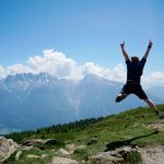 Man jumps in front of a mountain panorama in the Austrian Dolomites