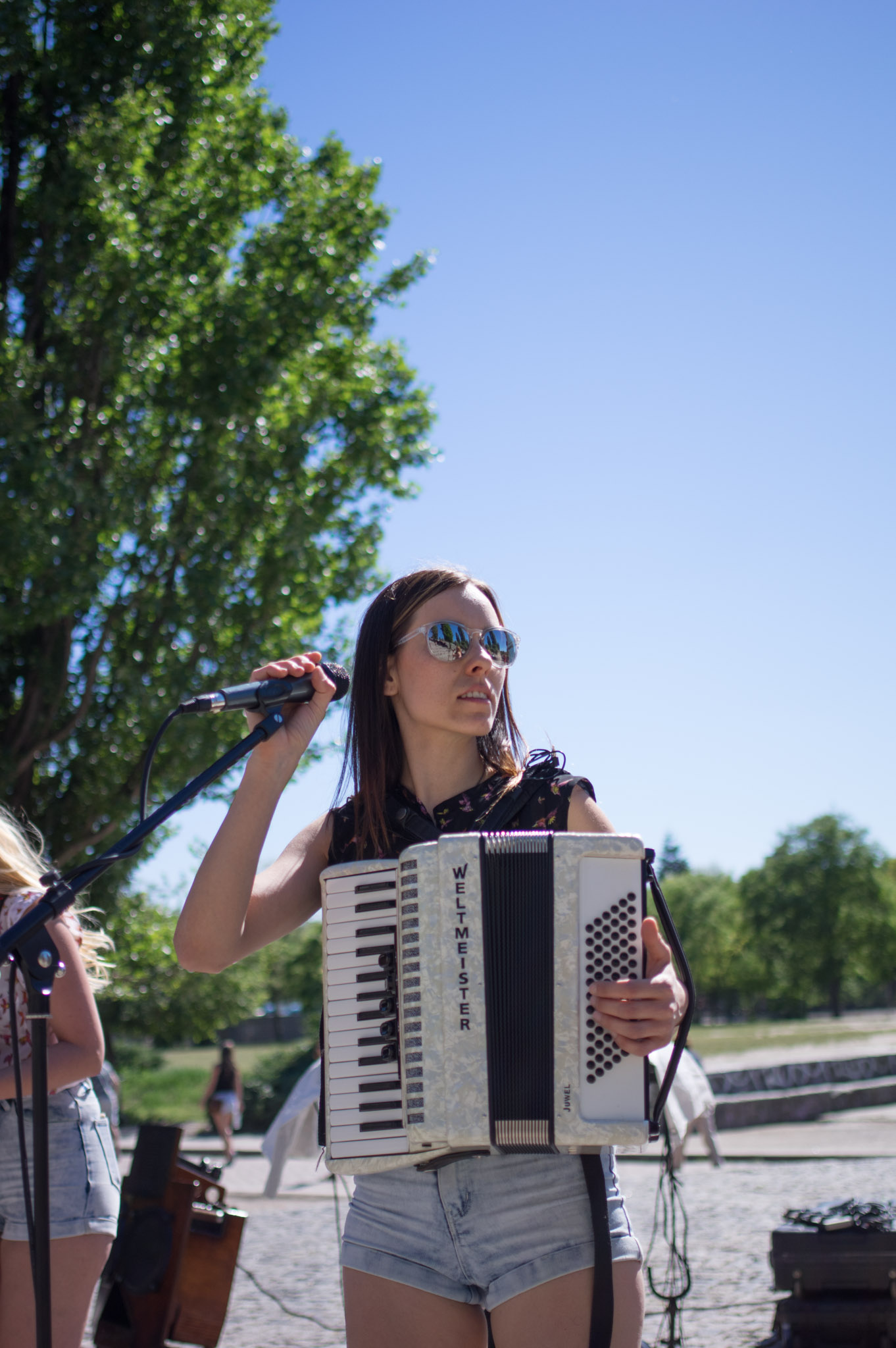 Woman playing the accordion and singing on an open-air-stage in Berlin
