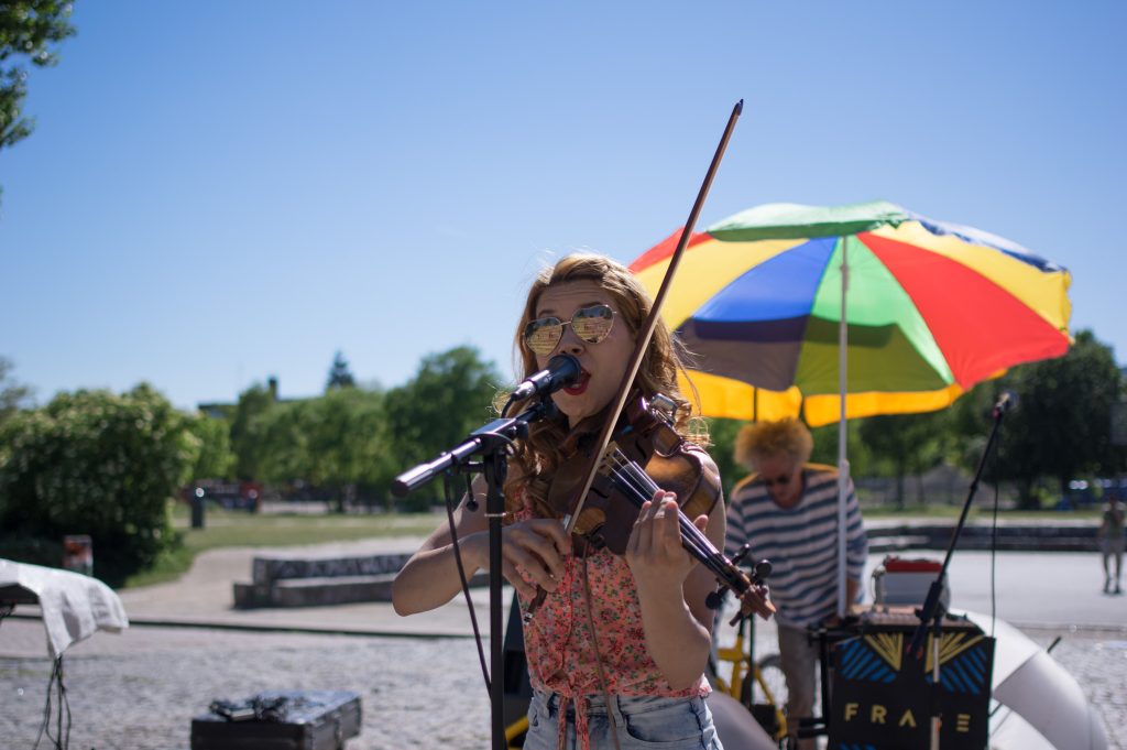 Woman playing the violin and singing on an open-air-stage in Berli