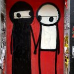 Two stick figures by street artist STIK in London, one showing a woman in a hidschab.