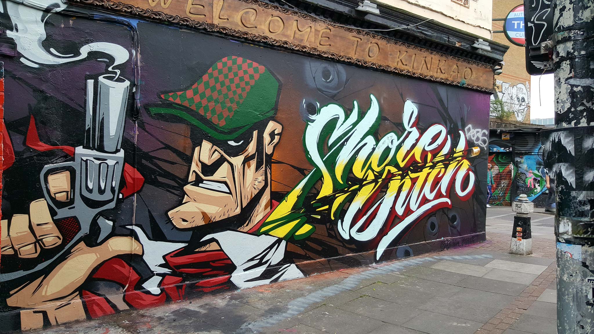 Streetart in Shoreditch, London, showing a gangster with a smoking gun